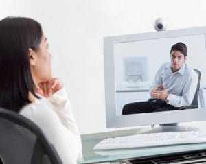 Businesswoman on Videoconference with Businessman --- Image by © Royalty-Free/Corbis